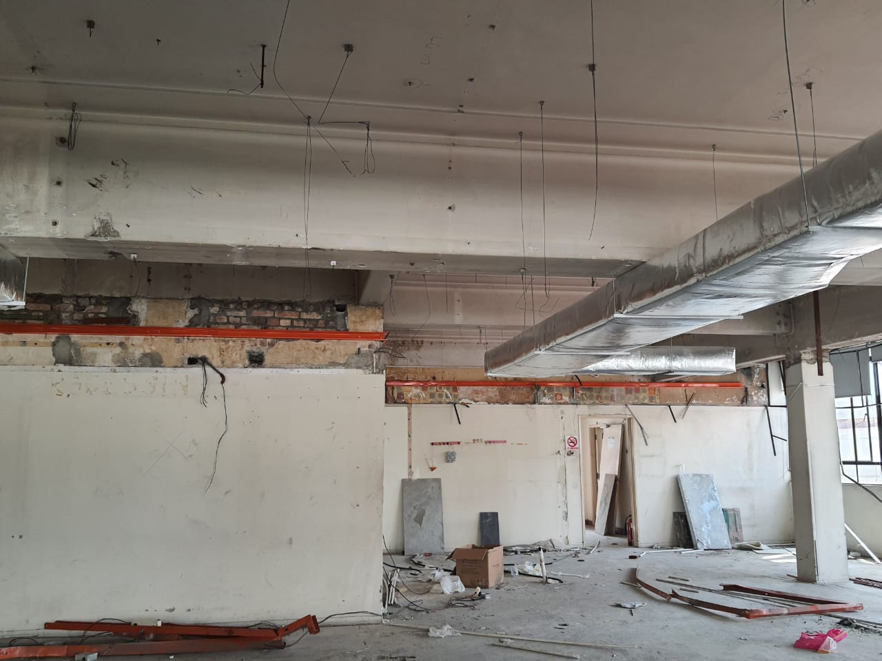 Wide view of the RHB Jalan Silang interior during renovation, showing walls, ceiling services and floor works in progress
